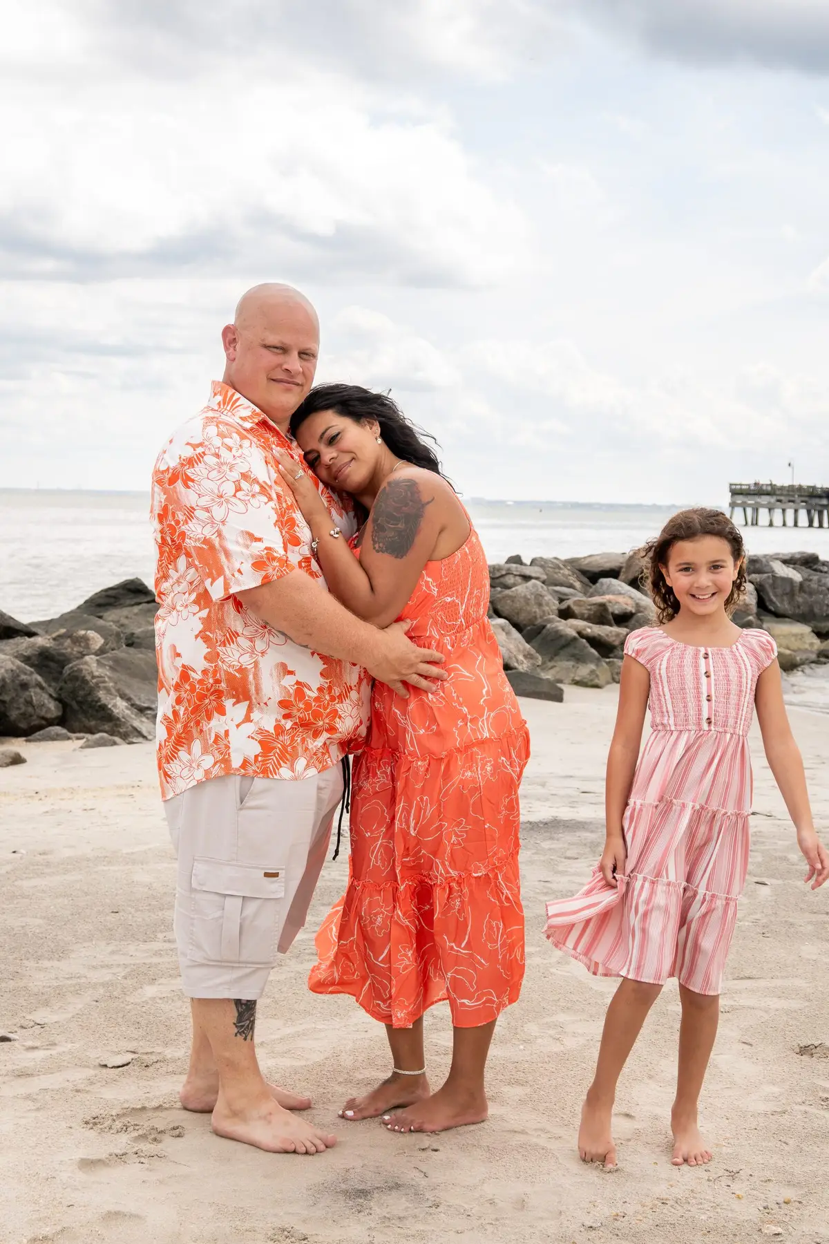 Family of four walking on the beach at sunset