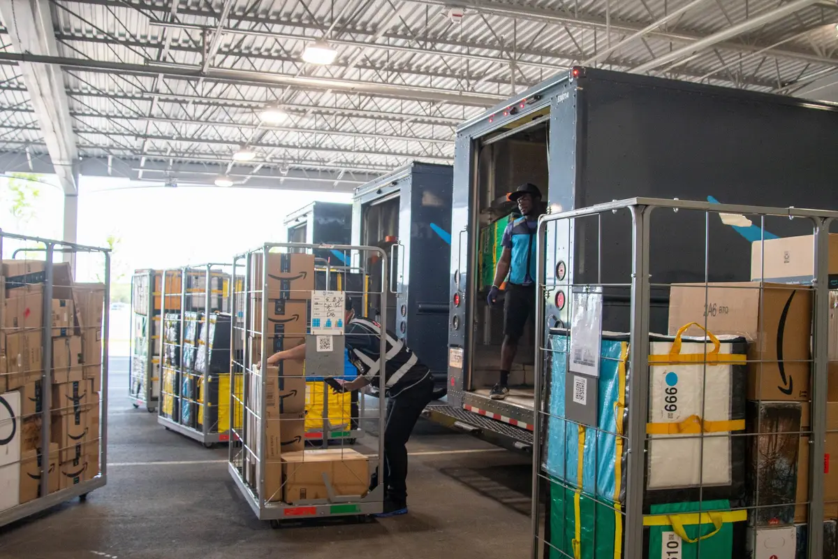 Workers moving a pallet of boxes in a warehouse