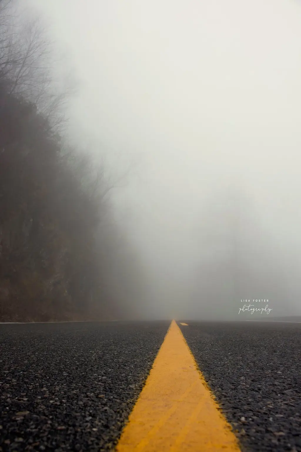Foggy mountain road with a yellow center line