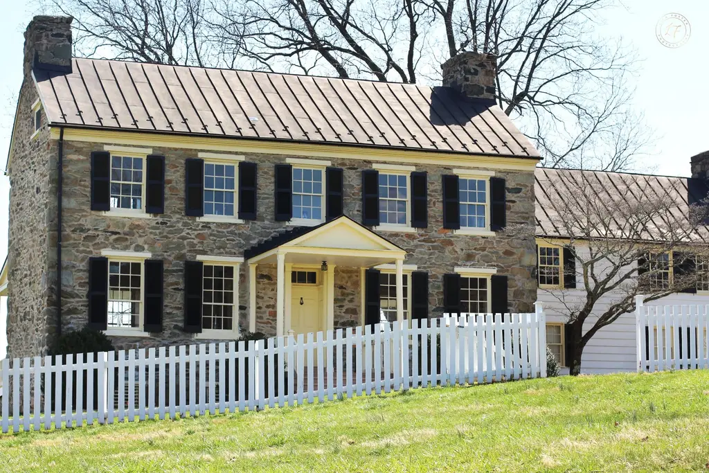 Historic stone house with a white picket fence