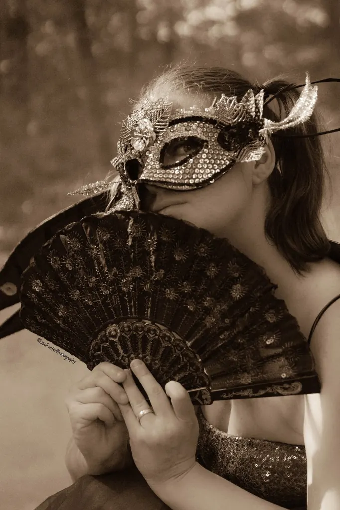 Sepia portrait with a lace mask and fan