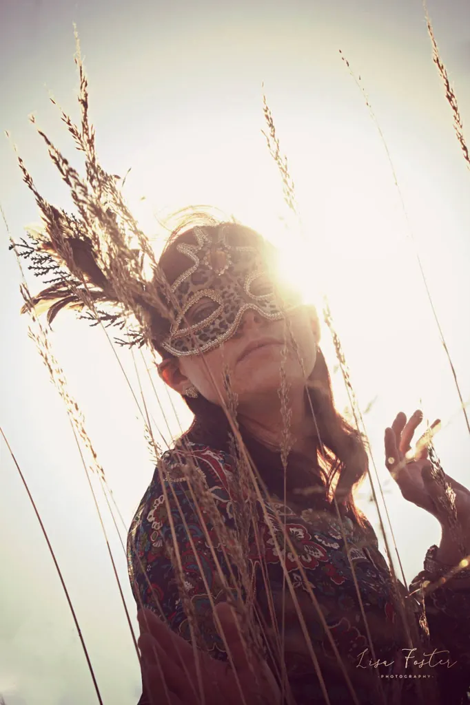 Backlit portrait among tall dry grasses