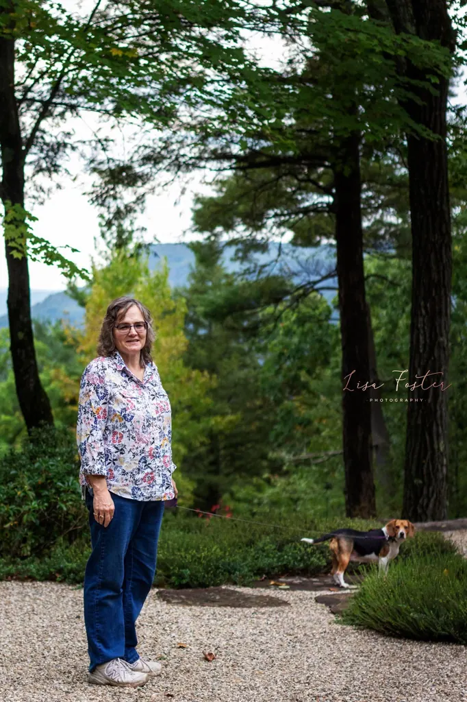 Woman standing on a garden path among tall trees