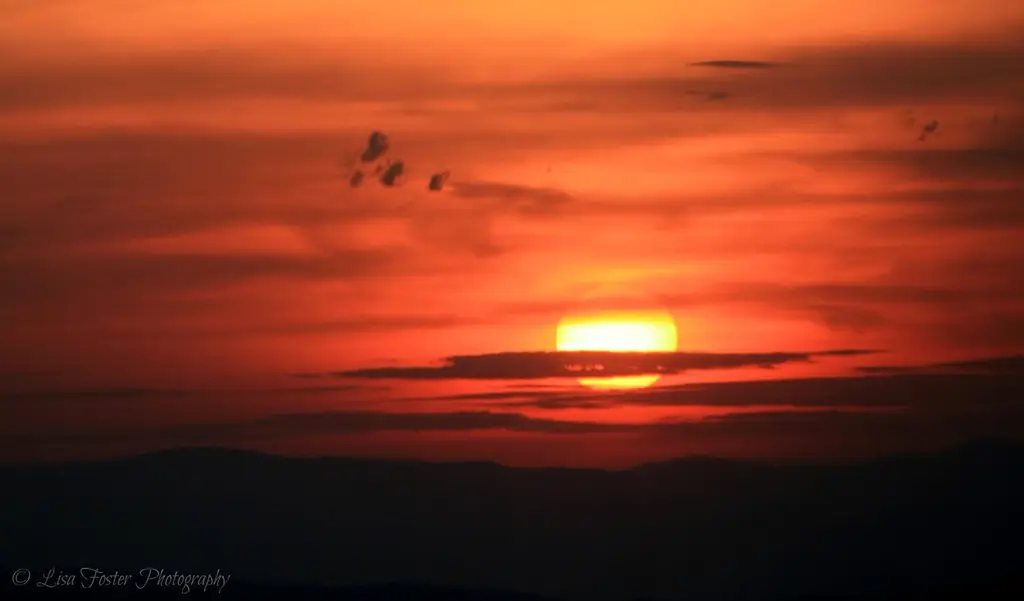 Red sun setting behind Shenandoah ridges