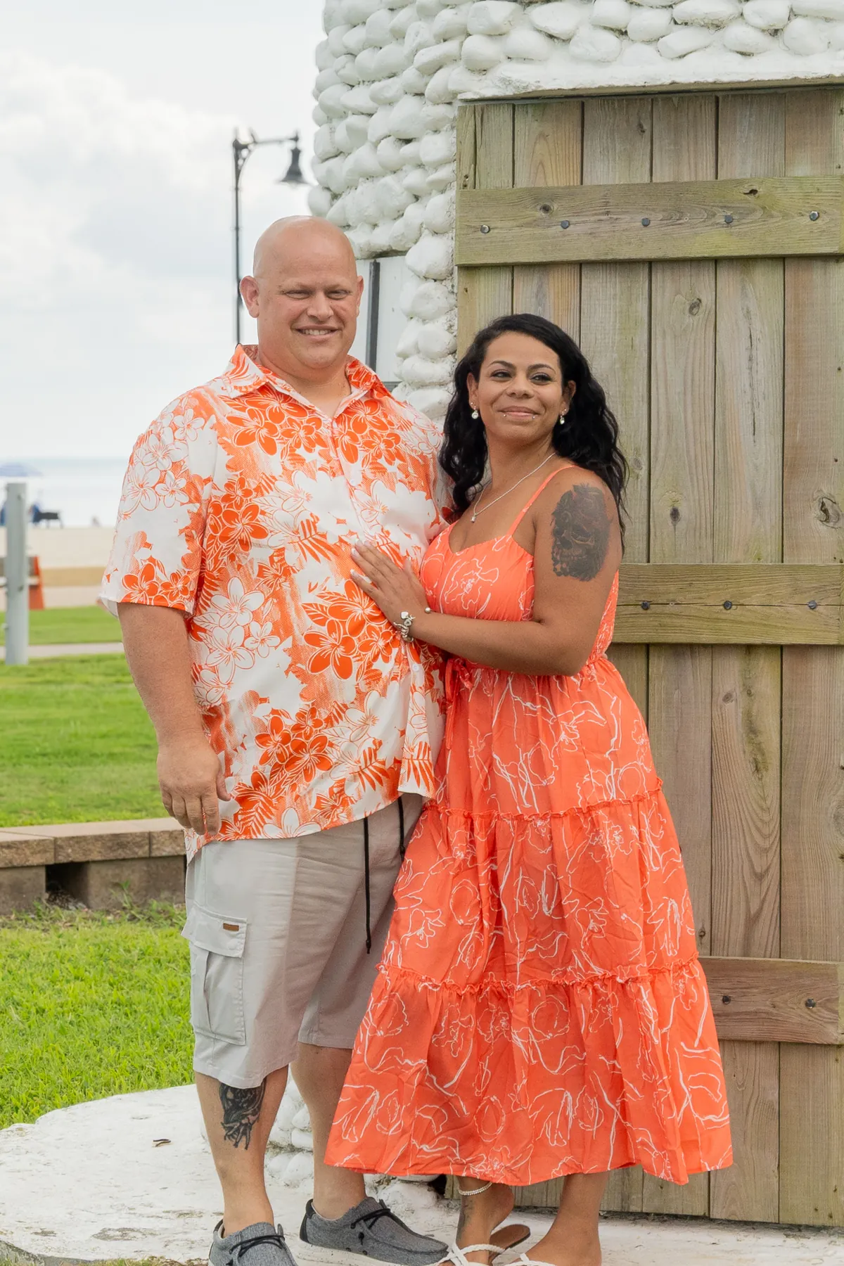 Smiling couple standing together outside a wooden lighthouse door
