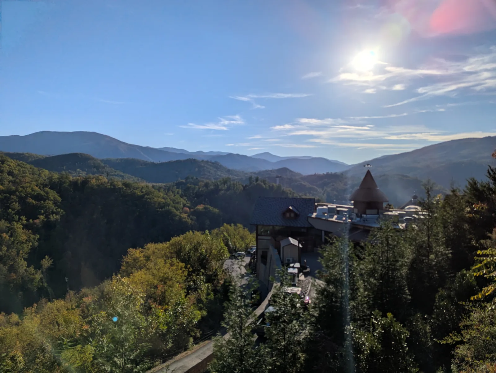 A wooden deck and rail above a deep valley, with a forested ridge on the far side