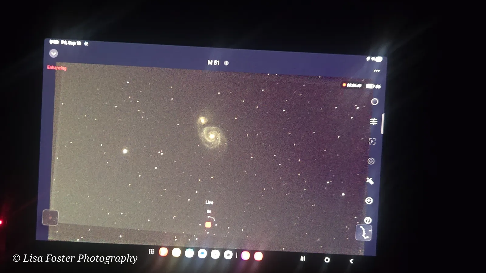 A wide tablet screen in the dark showing the Whirlpool Galaxy among stars, labeled M51