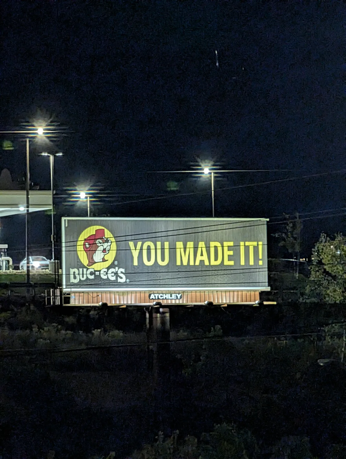A lit Buc-ee's billboard reading "You Made It!" against a dark night sky