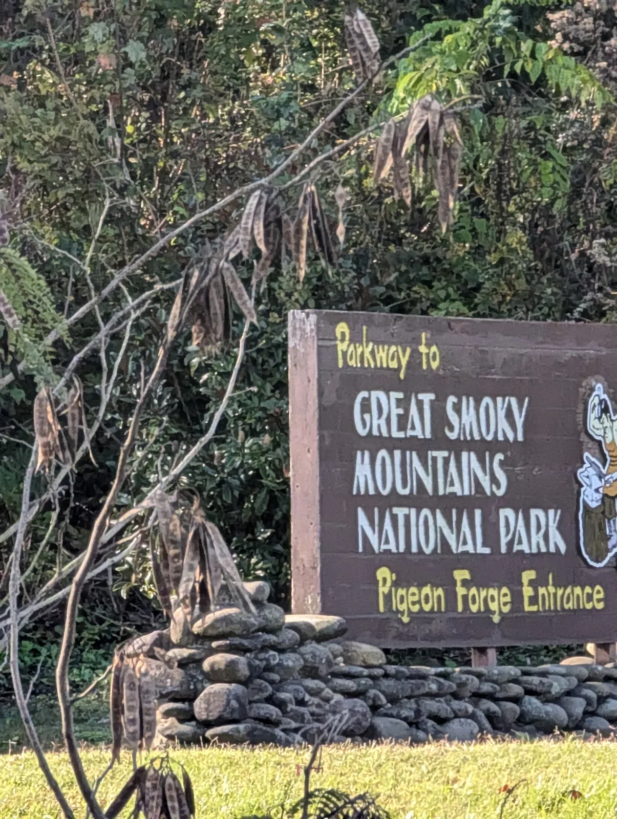 A brown roadside sign reading "Gateway to Great Smoky Mountains National Park," with a white arrow