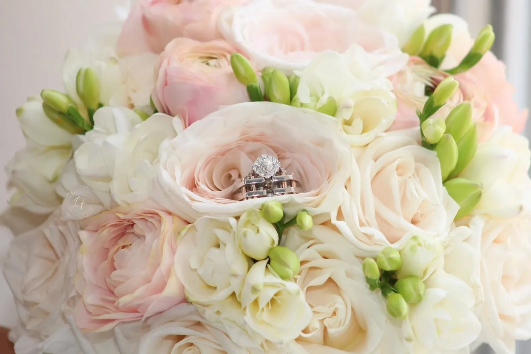 Blush and white rose bridal bouquet with wedding rings