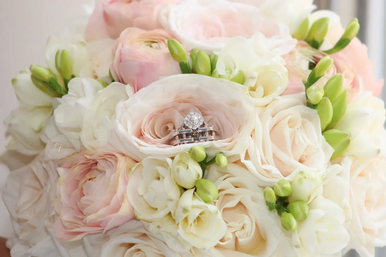 Blush and white bridal bouquet with wedding rings