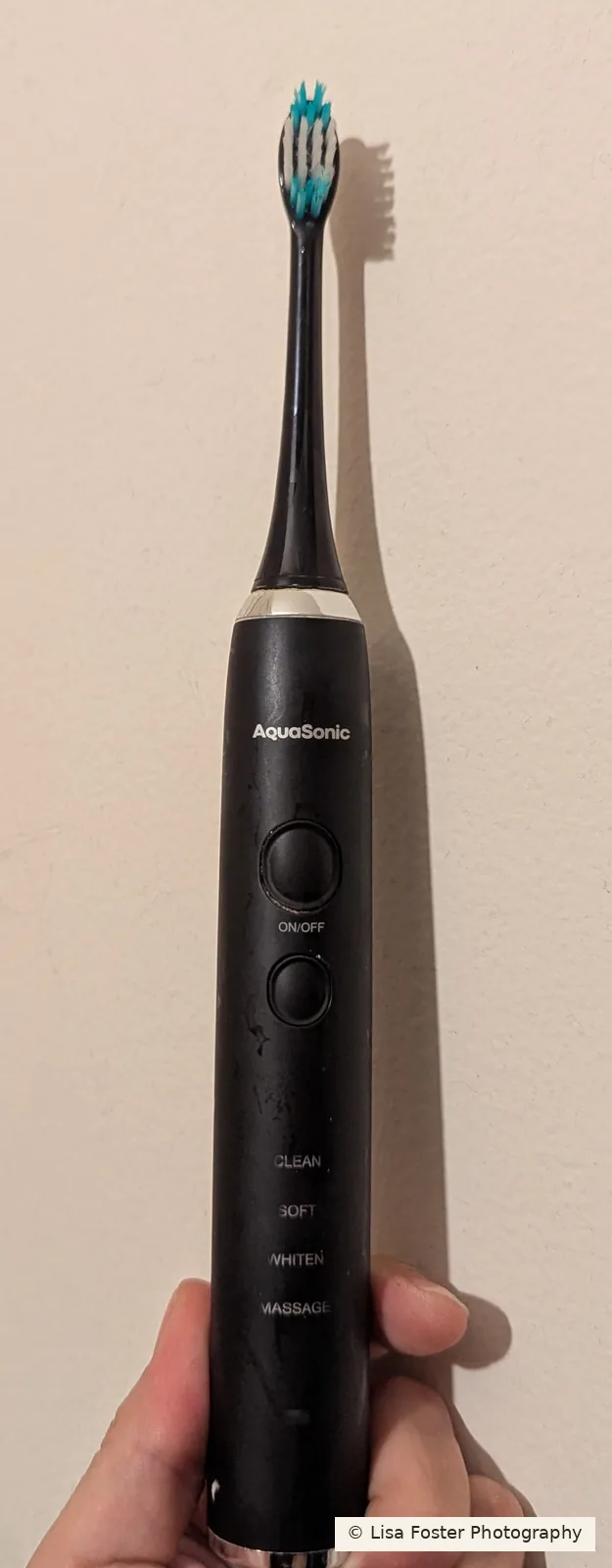 AquaSonic sonic toothbrush with Clean, Soft, Whiten, and Massage printed on the handle.