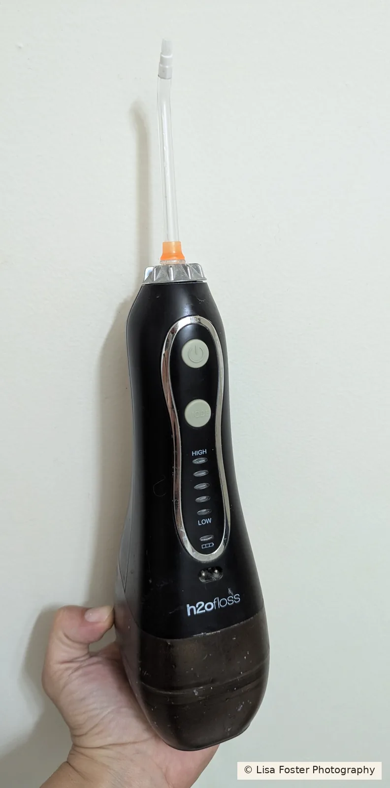 A black cordless H2ofloss water flosser with a clear tip.